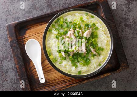 Koreanische Hühnersuppe Dak Gomtang, serviert mit Reis und grünen Zwiebeln in einer Schüssel auf dem Tisch. Horizontale Draufsicht von oben Stockfoto