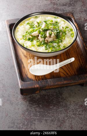 Die koreanische Hühnersuppe dak Gomtang wird aus langen, geschmortem Knochen und Aromaten aus der Nähe in einer Schüssel auf dem Tisch hergestellt. Vertikal Stockfoto