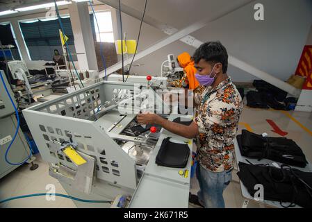 Gazipur, Dhaka, Bangladesch. 12. Oktober 2022. In einer Bekleidungsfabrik in Gazipur, Bangladesch, stellen Arbeiter Kleidung her. Vier von fünf der 4,4 Millionen Beschäftigten in der Bekleidungsindustrie in Bangladesch sind Frauen. Die Ready-Made-Garment-Industrie (RMG) ist ein Hauptpfeiler dieser wirtschaftlichen Erfolgsgeschichte. Bangladesch ist heute einer der größten Bekleidungsexporteure der Welt, wobei der RMG-Sektor 84 % der Exporte Bangladeschs ausmacht. Kredit: ZUMA Press, Inc./Alamy Live Nachrichten Stockfoto