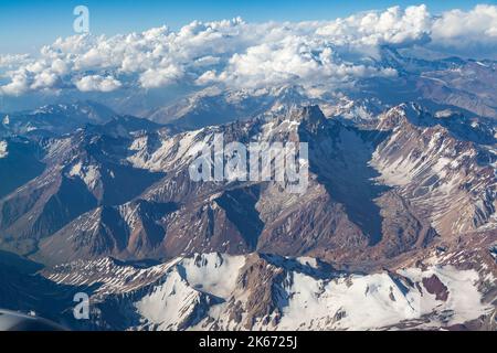 Luftaufnahme wunderschöne Landschaft der schneebedeckten Anden (Cordillera de los Andes), von einem Flugzeugfenster aus gesehen, in der Nähe von Santiago, Chile. Stockfoto