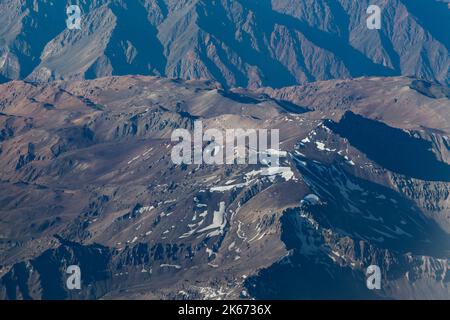 Luftaufnahme wunderschöne Landschaft der schneebedeckten Anden (Cordillera de los Andes), von einem Flugzeugfenster aus gesehen, in der Nähe von Santiago, Chile. Stockfoto