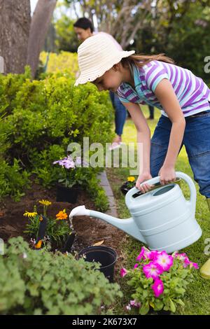 Kaukasische Mutter und Tochter verbringen Zeit zusammen im Garten und gießen Pflanzen Stockfoto