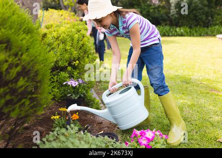 Kaukasische Mutter und Tochter verbringen Zeit zusammen im Garten und gießen Pflanzen Stockfoto