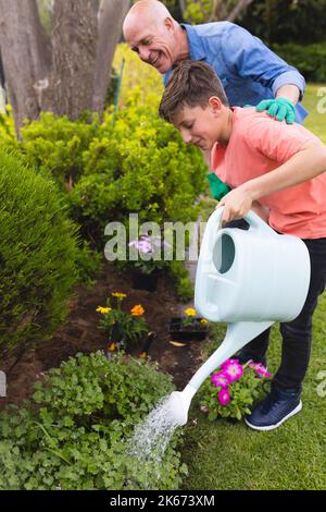 Kaukasischer Großvater und Enkel verbringen Zeit zusammen im Garten, Pflanzen Stockfoto