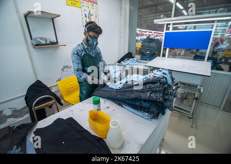 Gazipur, Dhaka, Bangladesch. 12. Oktober 2022. In einer Bekleidungsfabrik in Gazipur, Bangladesch, stellen Arbeiter Kleidung her. Vier von fünf der 4,4 Millionen Beschäftigten in der Bekleidungsindustrie in Bangladesch sind Frauen. Die Ready-Made-Garment-Industrie (RMG) ist ein Hauptpfeiler dieser wirtschaftlichen Erfolgsgeschichte. Bangladesch ist heute einer der größten Bekleidungsexporteure der Welt, wobei der RMG-Sektor 84 % der Exporte Bangladeschs ausmacht. Kredit: ZUMA Press, Inc./Alamy Live Nachrichten Stockfoto