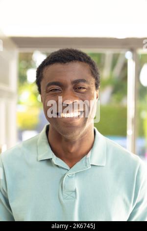 Ein vertikales Bild von glücklichen afroamerikanischen Männern, die jemanden außerhalb des Hauses begrüßen Stockfoto