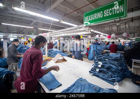 Gazipur, Dhaka, Bangladesch. 12. Oktober 2022. In einer Bekleidungsfabrik in Gazipur, Bangladesch, stellen Arbeiter Kleidung her. Vier von fünf der 4,4 Millionen Beschäftigten in der Bekleidungsindustrie in Bangladesch sind Frauen. Die Ready-Made-Garment-Industrie (RMG) ist ein Hauptpfeiler dieser wirtschaftlichen Erfolgsgeschichte. Bangladesch ist heute einer der größten Bekleidungsexporteure der Welt, wobei der RMG-Sektor 84 % der Exporte Bangladeschs ausmacht. Kredit: ZUMA Press, Inc./Alamy Live Nachrichten Stockfoto