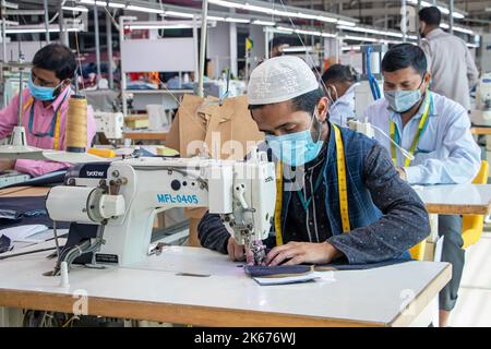 Gazipur, Dhaka, Bangladesch. 12. Oktober 2022. In einer Bekleidungsfabrik in Gazipur, Bangladesch, stellen Arbeiter Kleidung her. Vier von fünf der 4,4 Millionen Beschäftigten in der Bekleidungsindustrie in Bangladesch sind Frauen. Die Ready-Made-Garment-Industrie (RMG) ist ein Hauptpfeiler dieser wirtschaftlichen Erfolgsgeschichte. Bangladesch ist heute einer der größten Bekleidungsexporteure der Welt, wobei der RMG-Sektor 84 % der Exporte Bangladeschs ausmacht. Kredit: ZUMA Press, Inc./Alamy Live Nachrichten Stockfoto