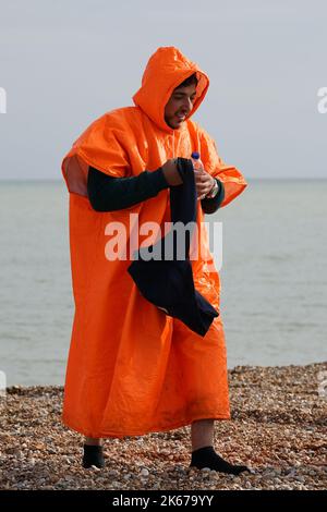 Ein Mann, der als Migranten gedacht wurde, geht über den Dungeness Strand, nachdem er vom Dungeness Rettungsboot nach einem Vorfall mit einem kleinen Boot im Kanal gebracht wurde. Bilddatum: Mittwoch, 12. Oktober 2022. Stockfoto