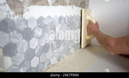 Keramikfliesen in Form von Wabenwaben und orientalischem Stil an einer weißen Wand. Fliesen aus naturfarbenen Sechsecken, die wie eine Wand zusammengestapelt sind, abstrakt Stockfoto