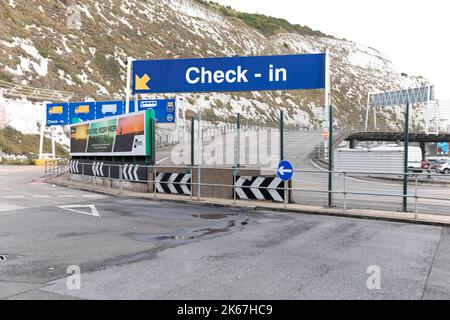 Ein großes Check-in-Schild auf einer leeren Einfahrtsstraße in Port of Dover, Kent, Großbritannien. Hinter dem Hotel befindet sich ein Blick auf die weißen Klippen von Dover. 7.. September 2022. Stockfoto