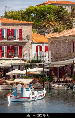 Cafés Restaurants und Bars entlang des Hafens mit Fischerbooten, die im ägäischen Seebad Molyvos auf der griechischen Insel Lesbos festgemacht sind Stockfoto