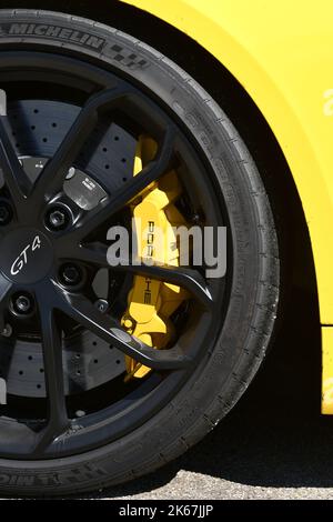 Mugello Circuit Italien 23. September 2022: Detail des schwarzen Leichtmetallrads eines Porsche 718 Cayman GT4 mit gelbem Bremssattel im Paddock von Muge Stockfoto