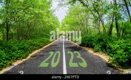 Frohes neues Jahr 2023 kommt Konzept mit 2023 Text auf der Straße. Das Fotobild kann als großes Display, als Druck, als Webbanner oder als Beitrag in sozialen Medien verwendet werden. Stockfoto