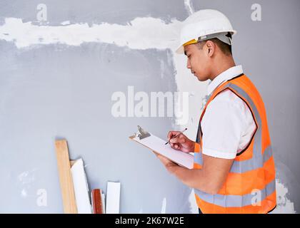 Ein Bauleiter überprüft das Renovierungsprojekt mit einer Checkliste auf der Zwischenablage Stockfoto