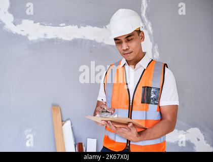 Ein Bauleiter überprüft das Renovierungsprojekt mit einer Checkliste auf der Zwischenablage Stockfoto