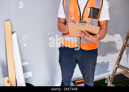 Ausgeschnittene Aufnahme des Vorgesetzten prüft Renovierungsprojekt mit Checkliste auf der Zwischenablage Stockfoto