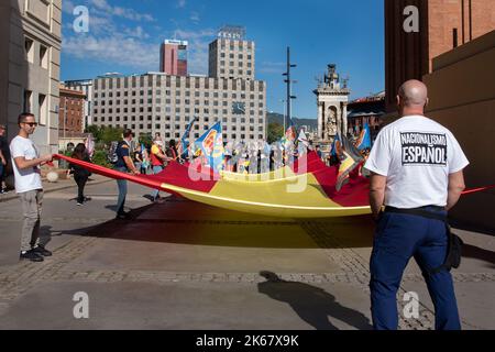 Barcelona, Spanien. 12. Oktober 2022. Spanische rechtsextreme Demonstranten versammeln sich mit einer riesigen spanischen Flagge auf der Plaza España, um den 12. Oktober, den spanischen Nationalfeiertag, im Rhythmus von Nazi-Gesängen und -Zeichen zu feiern. Kredit: SOPA Images Limited/Alamy Live Nachrichten Stockfoto
