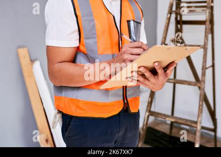 Ausgeschnittene Aufnahme des Vorgesetzten prüft Renovierungsprojekt mit Checkliste auf der Zwischenablage Stockfoto
