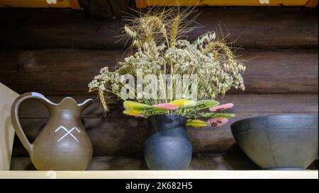 Keramikbecher und Tonvase mit getrockneten Blumen. Handwerk Ton Steingut Schalen in Handwerker-Klassen Werkstatt. Töpferei Stockfoto
