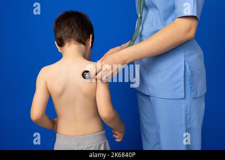 Der Arzt hört auf Herz und Lunge eines 5-jährigen Jungen mit Stethoskop. Stockfoto