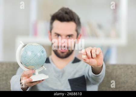 Porträt eines Mannes mit sim-Karte und Weltkugel Stockfoto