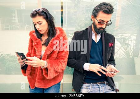 Hipster-Paar im traurigen Moment ignorieren einander mit Mobiltelefonen - Konzept der Apathie Traurigkeit süchtig nach neuen Technologien - Freund und Freundin Stockfoto