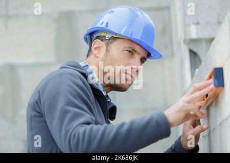 Bauarbeiter nivellieren eine Wand Stockfoto