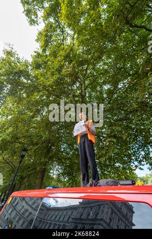 Zwei „Just Stop Oil“-Anhänger kletterten am Mittwoch (12. Oktober) inmitten eines fortlaufenden Wagens auf einen Metropolitan Police Van vor der Horse Guards Road in London Stockfoto