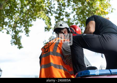 Zwei „Just Stop Oil“-Anhänger kletterten am Mittwoch (12. Oktober) inmitten eines fortlaufenden Wagens auf einen Metropolitan Police Van vor der Horse Guards Road in London Stockfoto