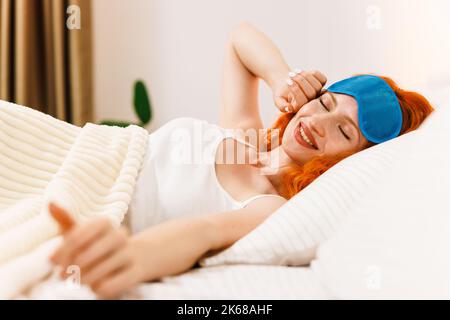 Portrait von attraktiven schönen Mädchen genießen Zeit in Bad nach dem Schlafen unter Decke liegend machen Stretching halten Augen geschlossen. Guter Tag Leben Gesundheit Stockfoto