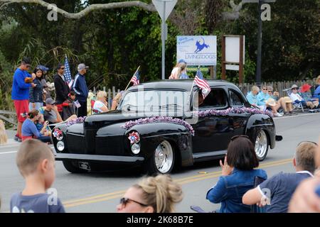 Ein Oldtimer, der mit amerikanischen Flaggen für die Parade zum Unabhängigkeitstag geschmückt ist Stockfoto