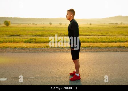 Ein gutaussehender Athlet atmet an der Startlinie vor dem Wettkampf Luft ein. Stockfoto