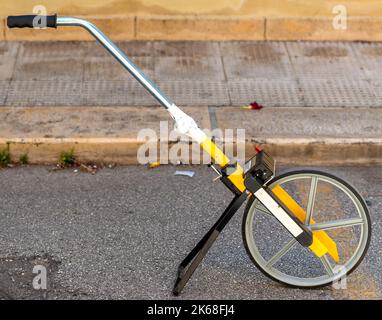 Feldmaß Rad oder Clickwheel zur Messung der Entfernungen auf Straßen oder Gehwegen durch Straße oder Dienstprogramm Wartungspersonal Stockfoto