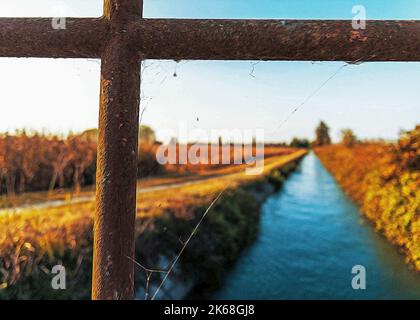 Brücke über einem bewässerungskanal der Lomellina bei Sonnenuntergang Stockfoto