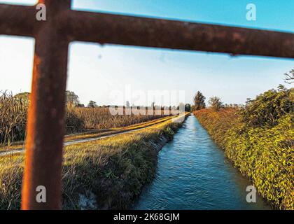 Brücke über einem bewässerungskanal der Lomellina bei Sonnenuntergang Stockfoto