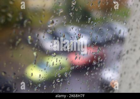 Regentropfen auf dem Glas des Fensters auf dem Hintergrund der Stadt Stockfoto