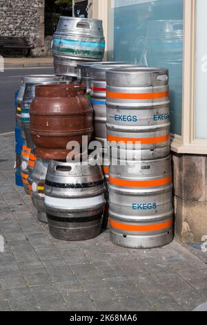 Ein Stapel von Bier- und E-Fässern aus Metall wartet auf die Abholung auf dem Bürgersteig vor dem Hotel Stockfoto