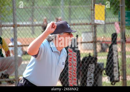 Softball Schiedsrichter für ASA in den USA, während Spiele telefonieren und in Pregame Überprüfung solcher Streik und Regeln, Fledermäuse und Aufstellungen Stockfoto