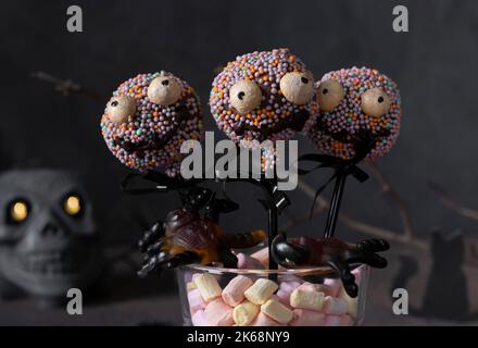 Cake Pops als gruselige Monster aus dunkler Schokolade für Kinder auf Halloween-Party Stockfoto