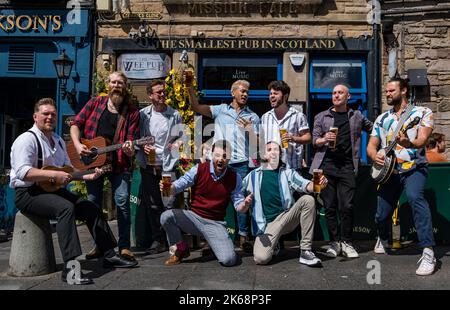 Chor der man-Gruppe singt, spielt Musik und trinkt Bier in der kleinsten Kneipe in Schottland, Grassmarket, Edinburgh, Schottland, Großbritannien Stockfoto