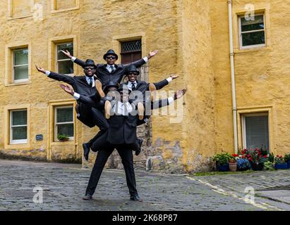 Die akrobatische Gruppe der Black Blues Brothers treten im Dean Village auf, um eine menschliche Pyramide zu erschaffen, Edinburgh, Schottland, Großbritannien Stockfoto