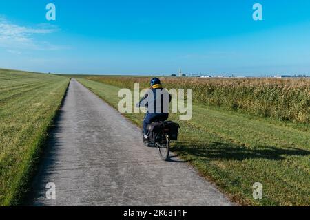 Frau auf dem Fahrrad auf dem Weserradweg südlich von Bremerhaven. Stockfoto