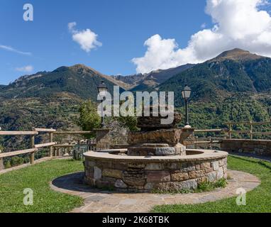 Kreisförmiger Aussichtspunkt aus Stein und Rastplatz hoch über einem Bergtal, traditionelles spanisches Dorf, Pyrenäen, Spanien Stockfoto
