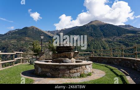Kreisförmiger Aussichtspunkt aus Stein und Rastplatz hoch über einem Bergtal, traditionelles spanisches Dorf, Pyrenäen, Spanien Stockfoto