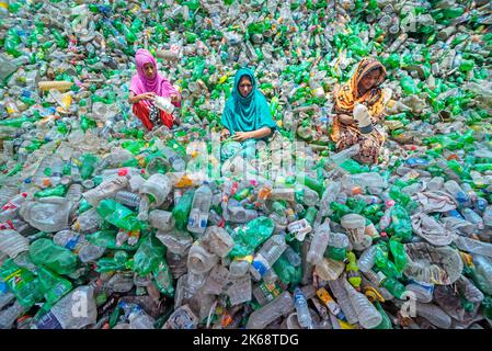 Arbeiter sortieren gebrauchte Plastikflaschen in einer Recyclingfabrik. Das Recycling von Kunststoffen ist der beste Weg, um unsere Umwelt sauber und sicher zu machen. Stockfoto