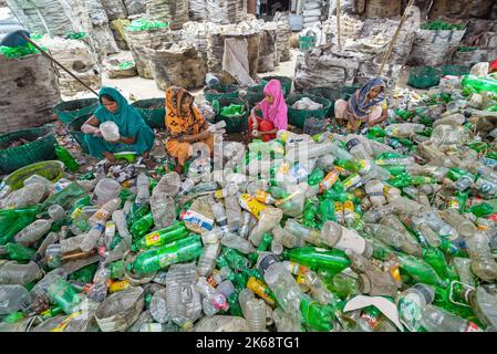 Arbeiter sortieren gebrauchte Plastikflaschen in einer Recyclingfabrik. Das Recycling von Kunststoffen ist der beste Weg, um unsere Umwelt sauber und sicher zu machen. Stockfoto