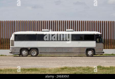 Eagle Pass, USA. 12. Oktober 2022. Am 10. Oktober 2022 wird ein Bus mit Migranten entlang eines Teils der Grenzmauer in Eagle Pass, Texas, USA, gesehen. Busse, die Migranten aus republikanisch geführten Grenzstaaten transportieren, kommen weiterhin in liberalen Bastionen wie New York, Washington, DC und Chicago an und ziehen die US-Migrationskrise in die Augen des Sturms der Partisanenkämpfe vor den Zwischenwahlen im November. Quelle: Nick Wagner/Xinhua/Alamy Live News Stockfoto