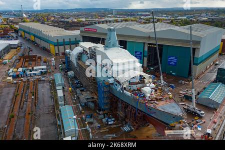 Glasgow, Schottland, Großbritannien. 12.. Oktober 2022. Blick auf die HMS Glasgow das erste Typ 26-U-Boot-Kriegsschiff, das auf der BAE Systems Werft in Govan am Fluss Clyde in Glasgow gebaut wird. BAE System plant Investitionen in Höhe von £100 Millionen und rekrutiert fast 1.200 weitere Mitarbeiter in seiner britischen Schiffbauabteilung, davon 400 bei Govan. Die Werft freut sich auf die Auftragseingänge von zehn Jahren, da die Minister sich darauf vorbereiten, einen Deal für fünf weitere Schiffe der Type 26-Klasse zu unterzeichnen. Iain Masterton/Alamy Live News Stockfoto