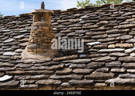 Altes spanisches Steindach auf einem Dorfgrundstück bei Sommersonne Stockfoto